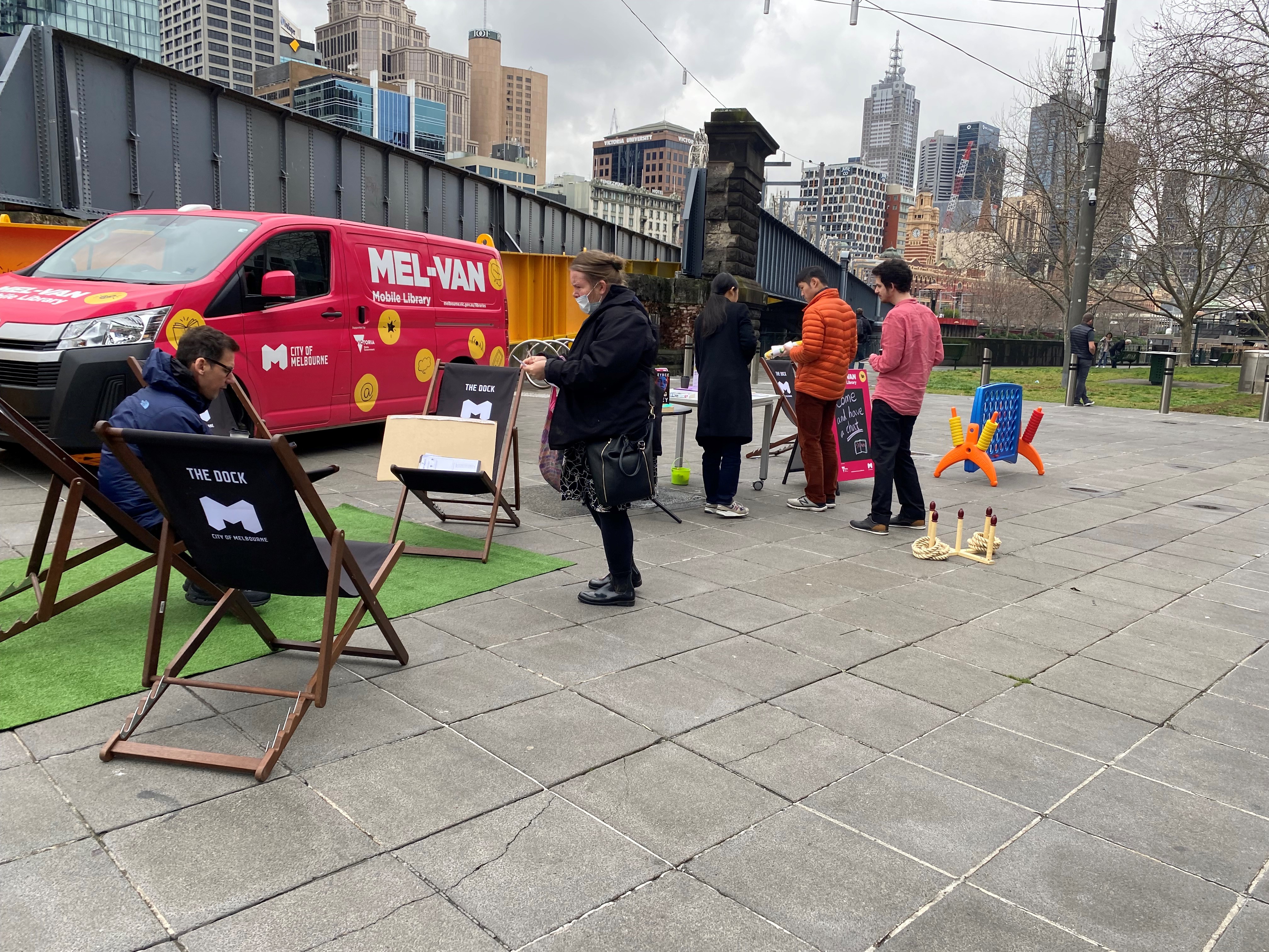 Some members of the public having a look at the city of melbourne libraries mel-van and some of the activities that it contains